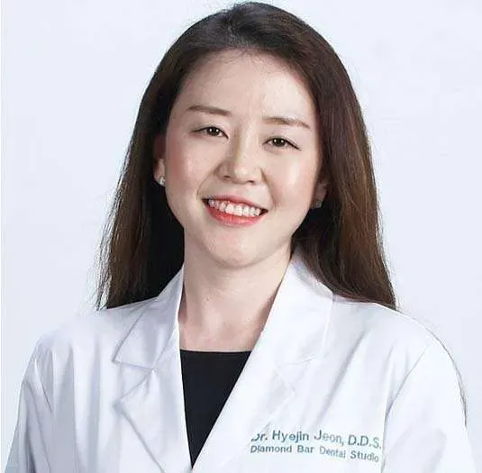 흰 가운을 입은 여성 의사의 headshot 사진.